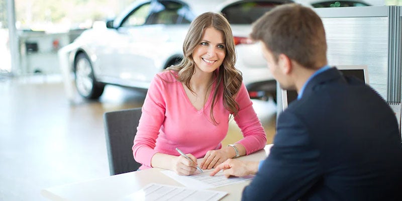 Car shopper and salesperson talking at a dealership